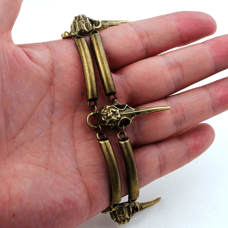 Crow skull bracelet detail shot on human palm, close-up of antiqued bronze skull decoration and metal craftsmanship