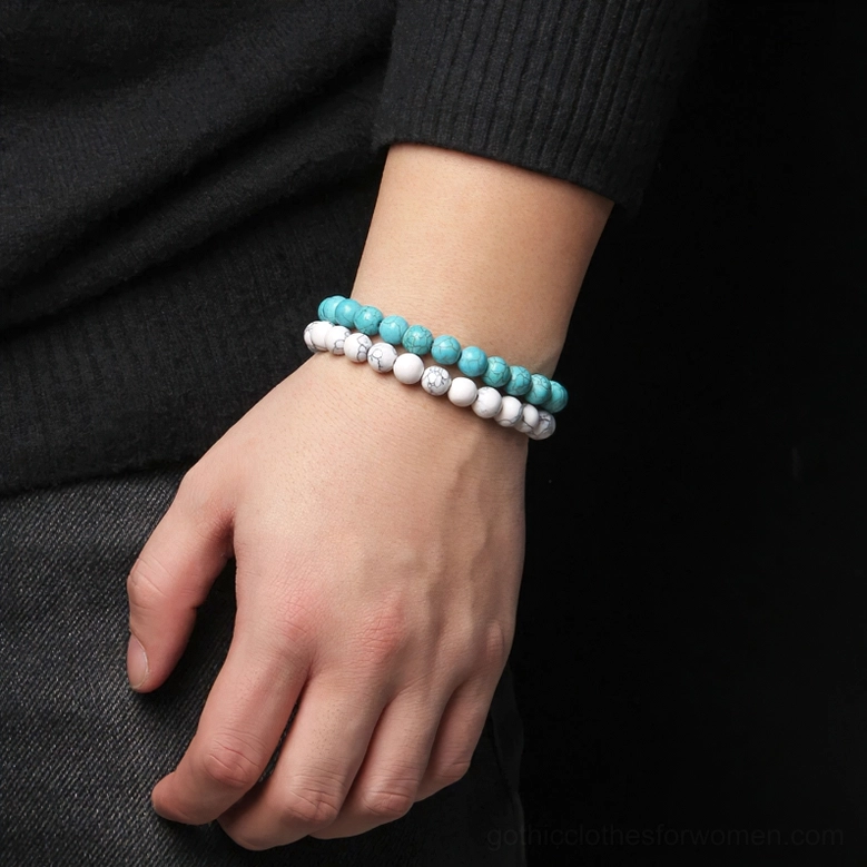Turquoise and white natural stone beaded bracelet worn on male wrist, side angle close-up, dark studio background, styling reference