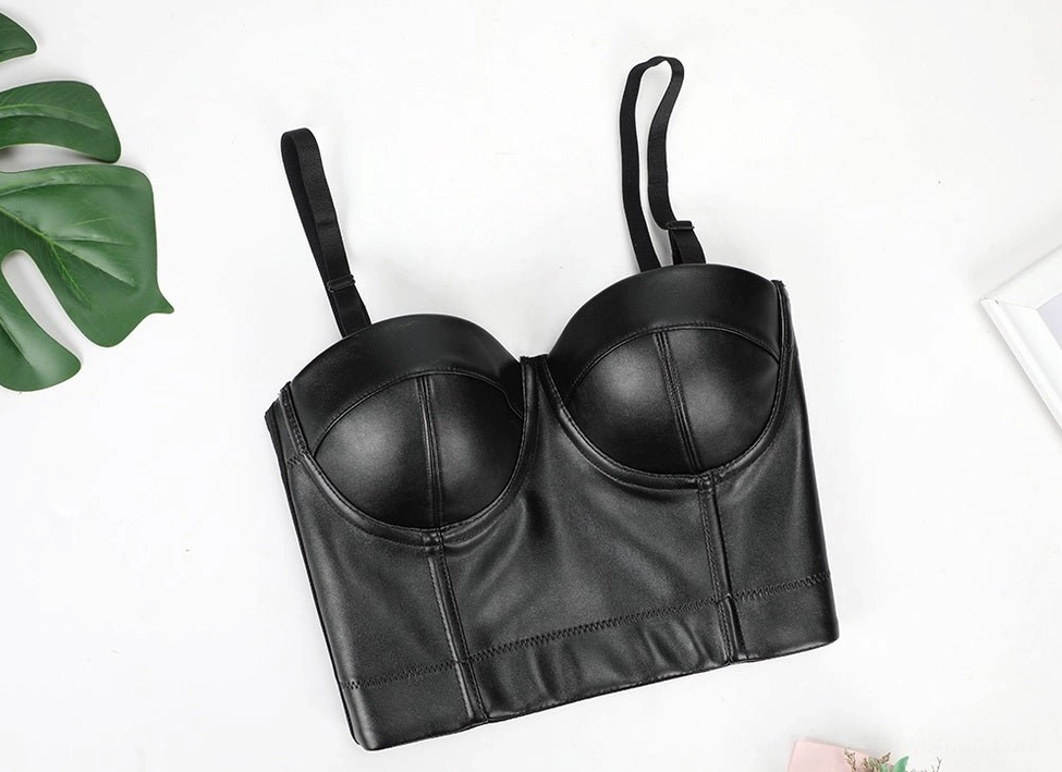 Black PU leather bustier bra front flat lay with leaf decor background, emphasizing smooth leather surface and push-up underwire