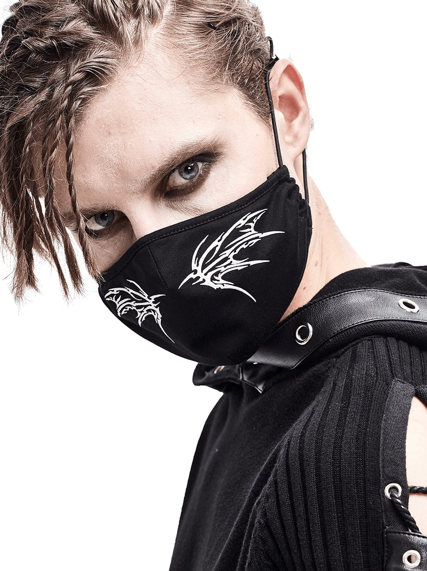 Black gothic butterfly wing face mask modeled by person with braided dreadlocks, three-quarter close-up view showcasing white wing print detail