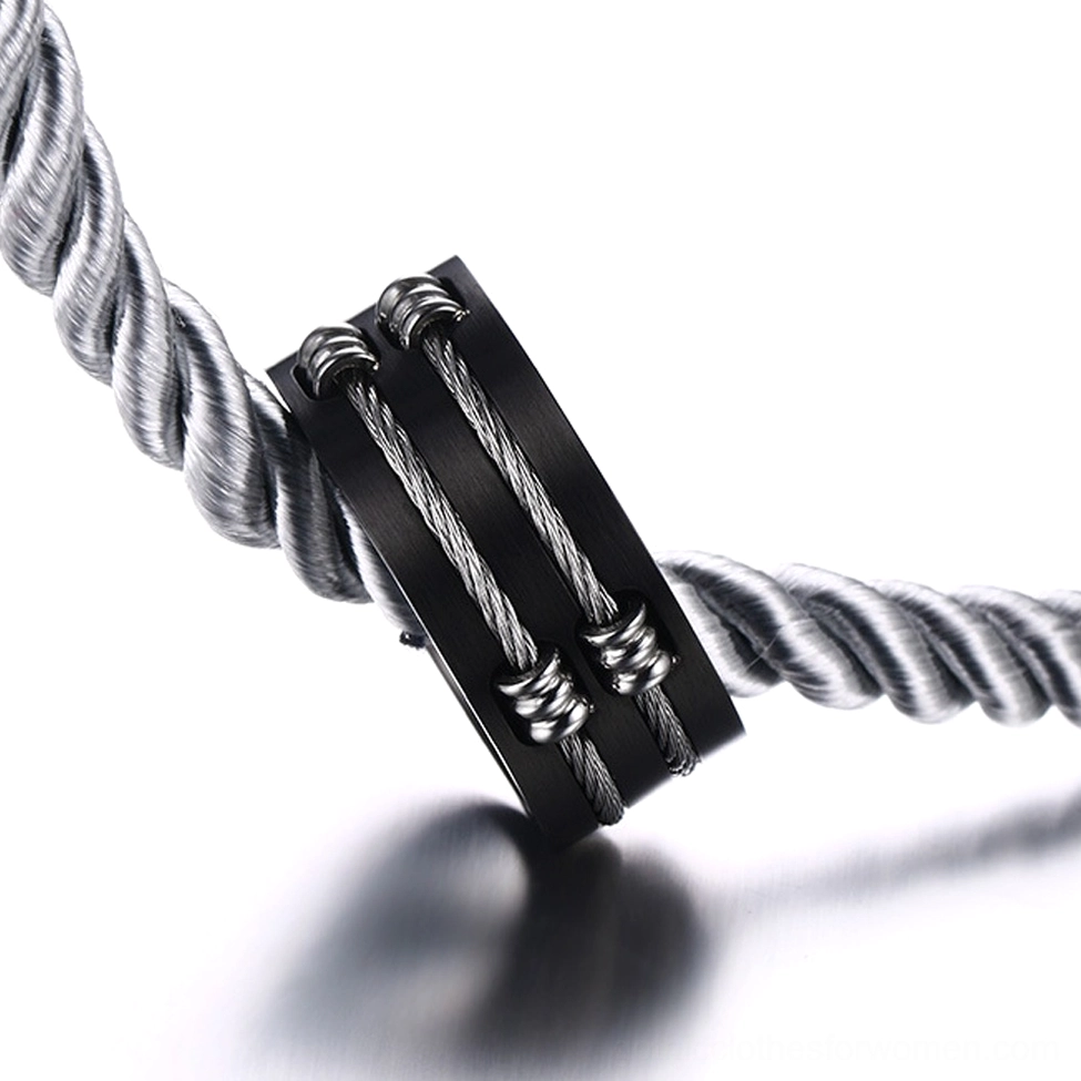 Black cable inlay gothic ring displayed on twisted rope with reflective studio background, showcasing industrial aesthetic and metal craftsmanship