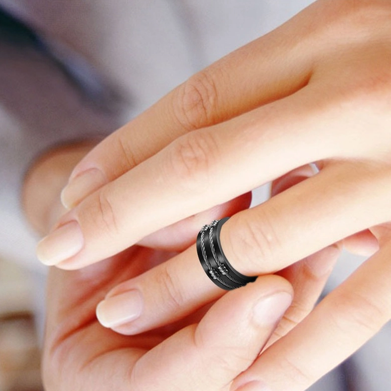 Unisex gothic ring worn on female finger, close-up side view in studio setting, demonstrating elegant fit and twisted wire detail on delicate hand