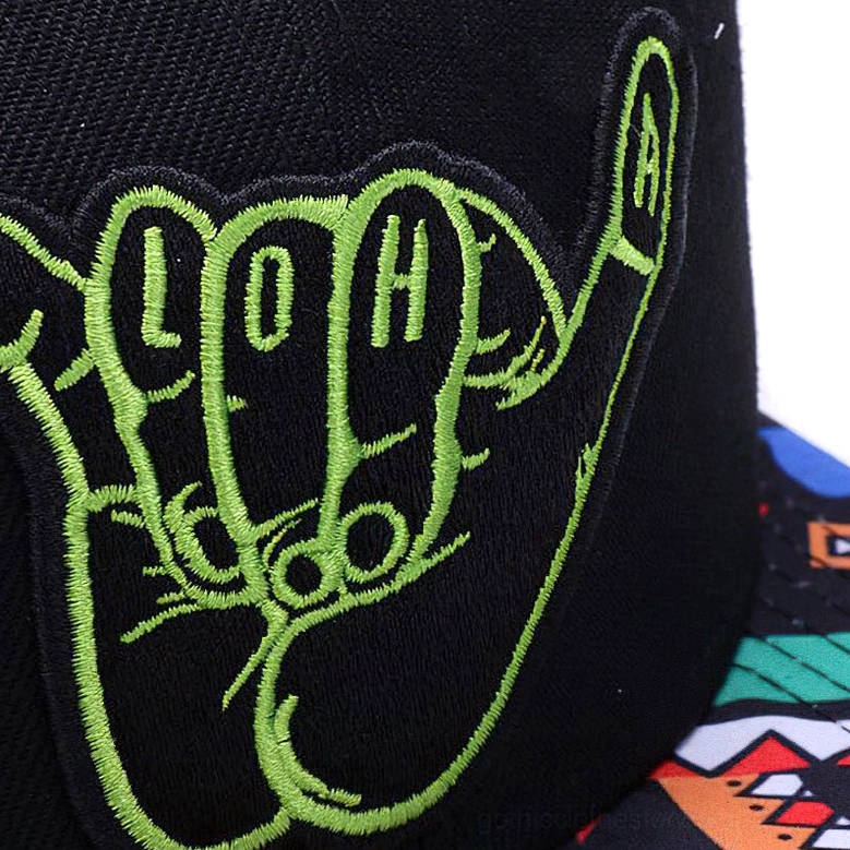 Close-up macro detail of green shaka hand embroidery on black woven cotton fabric of gothic snapback cap
