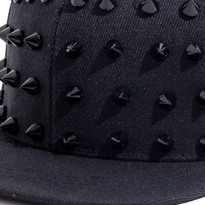 Close-up detail of dense black cone spikes on cap crown showing texture and metallic finish