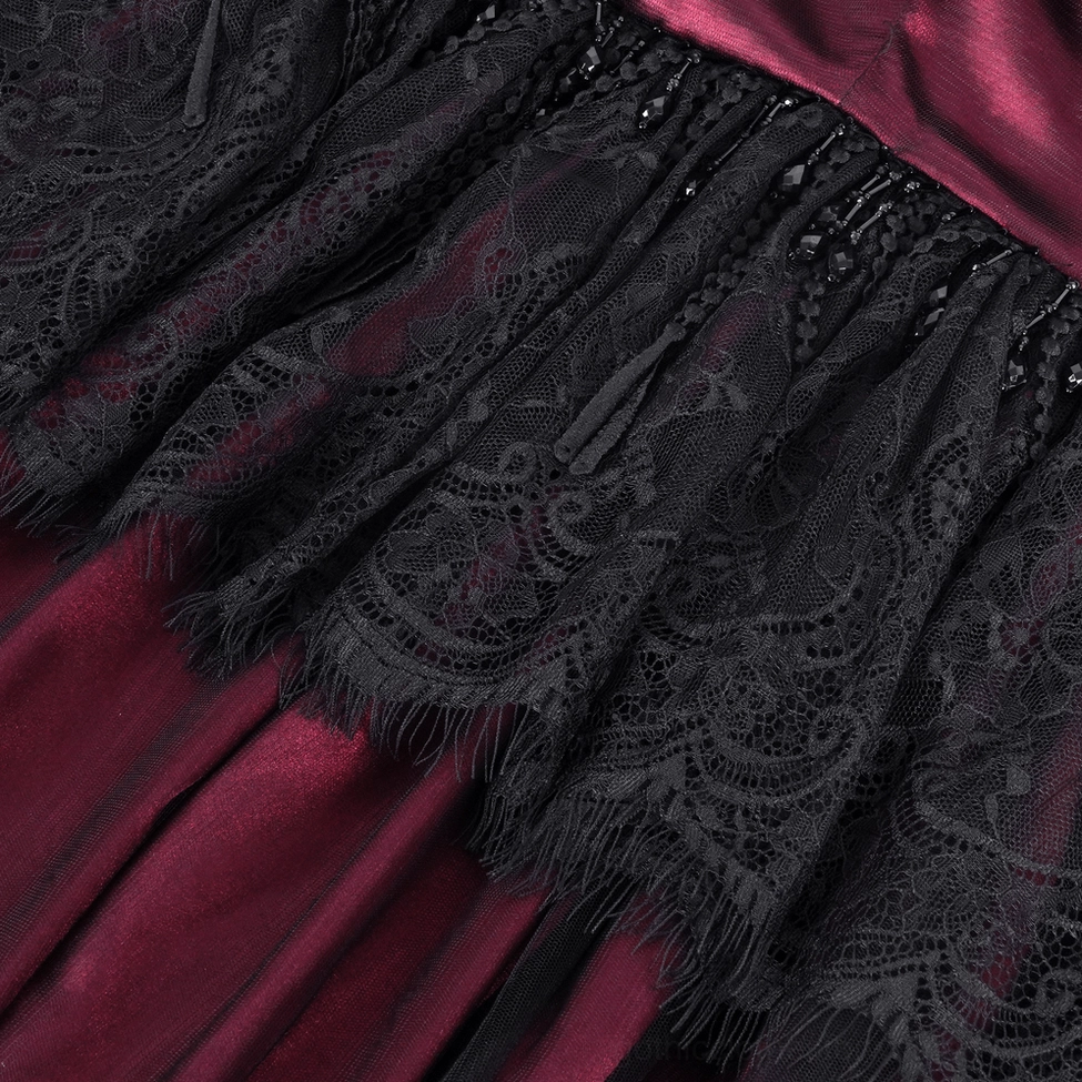 Close-up detail of gothic cape black floral lace overlay with frayed lace edges on wine red satin base showing craftsmanship
