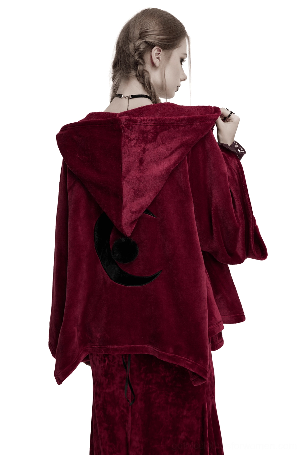 Black crescent moon embroidery detail on back of burgundy velvet gothic cape, worn by female model in studio setting