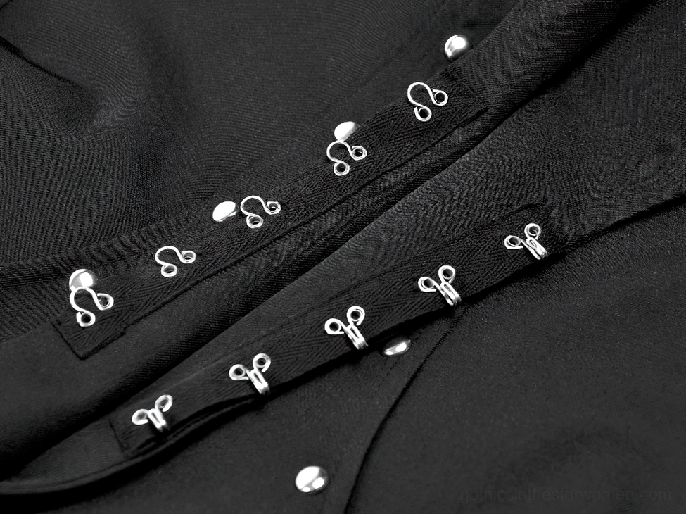 Black studded cape construction detail - architectural seaming and stud placement on gothic fashion piece