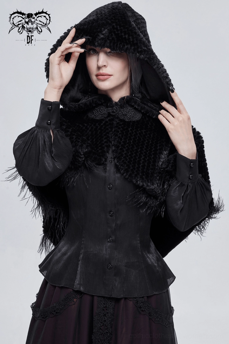 Black gothic cape styled flat lay showing hood, pom-pom hem, and feather fringe construction