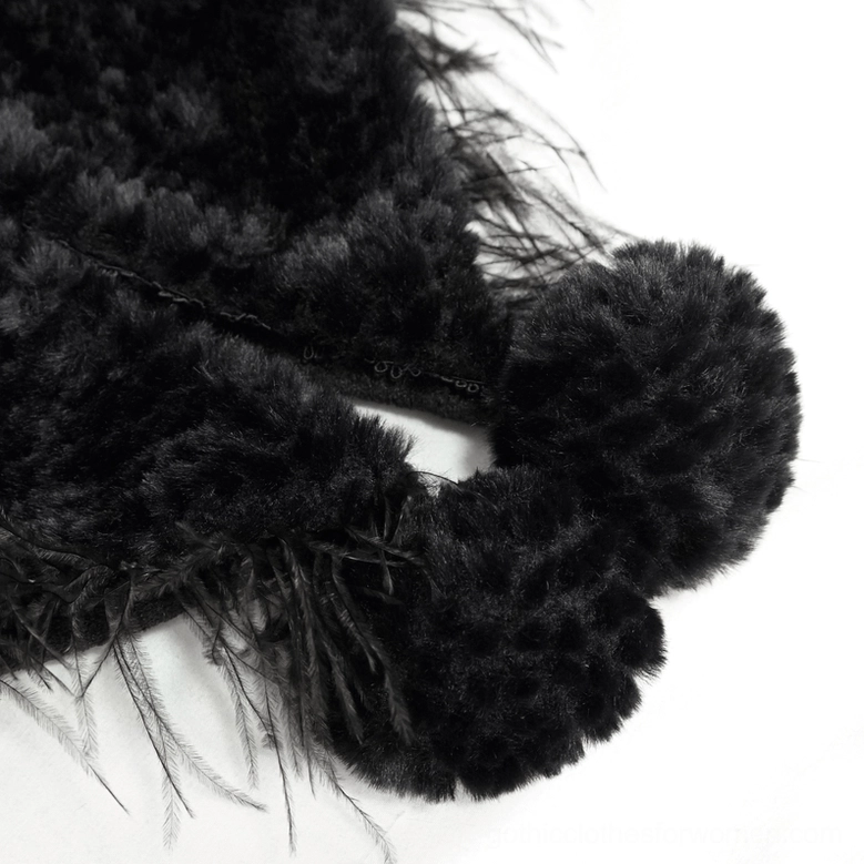 Close-up of gothic cape frog-style closures and fluffy black pom-poms on grainy plush material