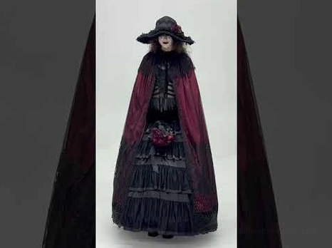 Gothic cape and gown set detail showing layered black ruffled skirt with wine red and black coordinated dark fashion ensemble