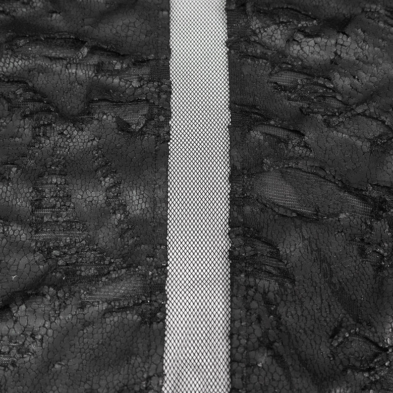 Black gothic asymmetrical cape detail shot showing irregular hemline construction and fabric quality