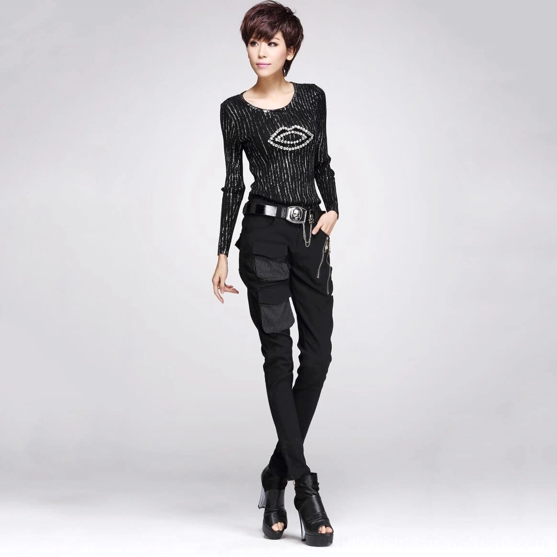 Black gothic cargo pants styled with lip print knit top and skull belt on female model