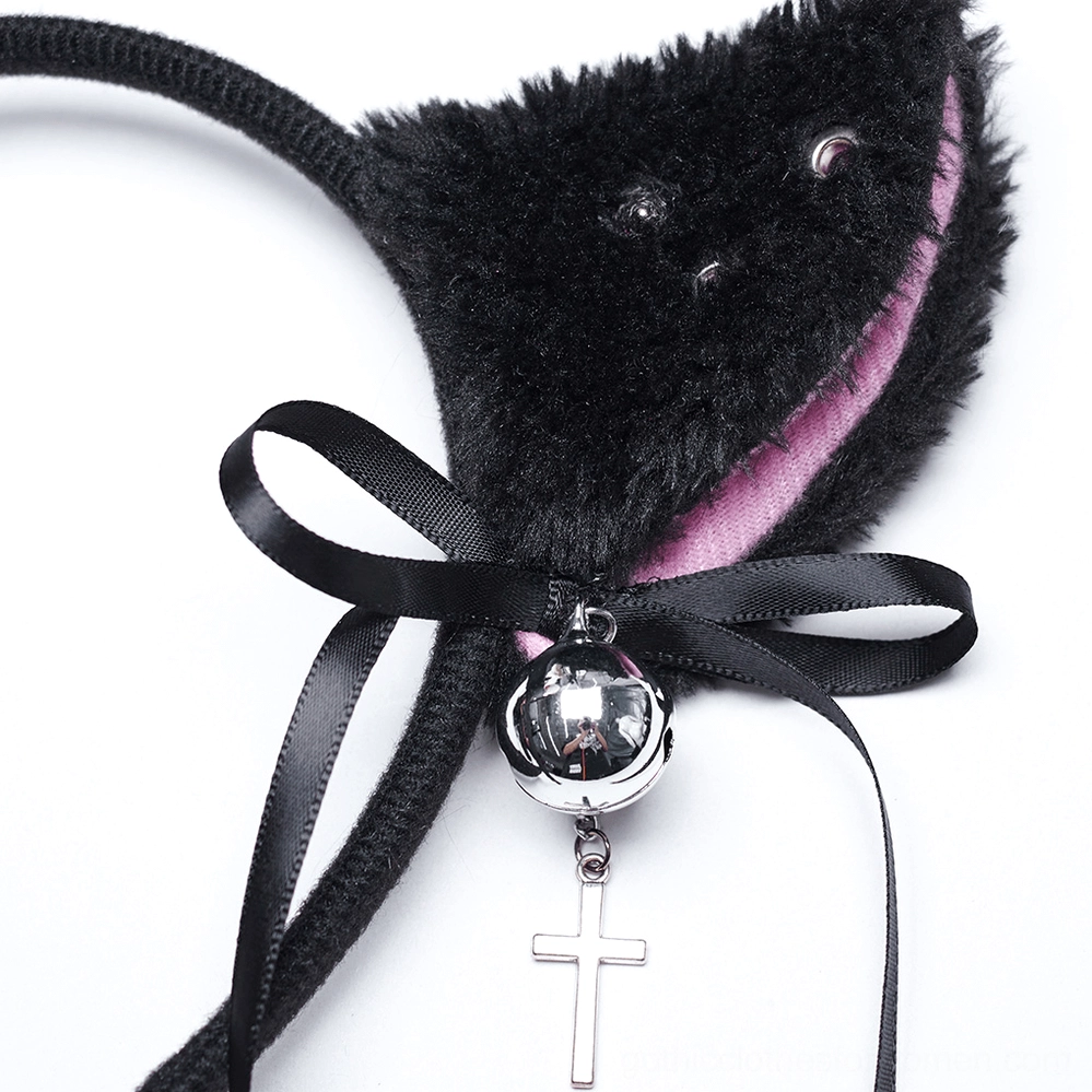 Single black plush cat ear closeup with pink inner lining and large silver bell with cross pendant attached to black satin bow