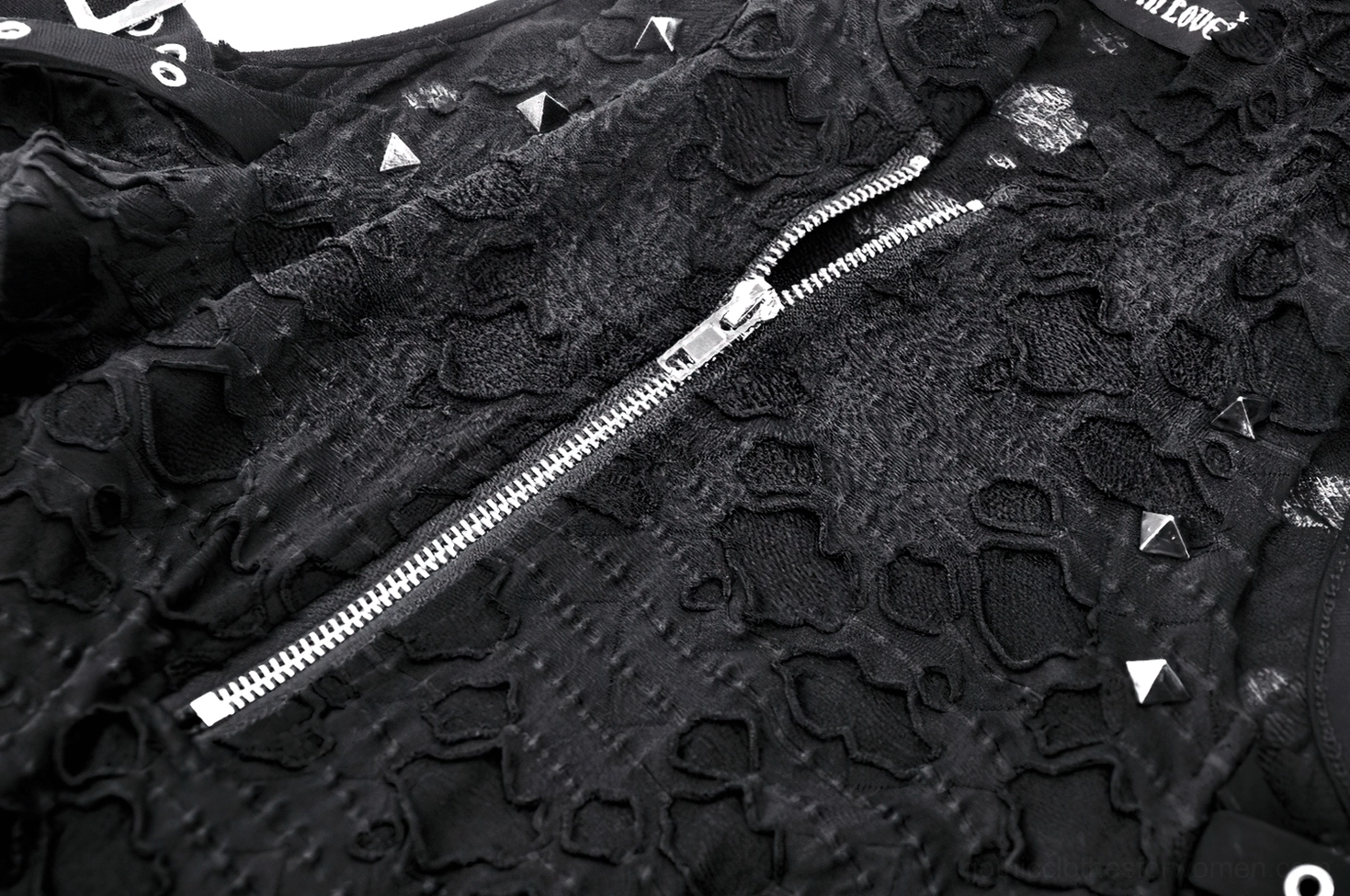 Close-up detail of sculptural cat-ear hood on black lace gothic dress showing brand label and lace lining