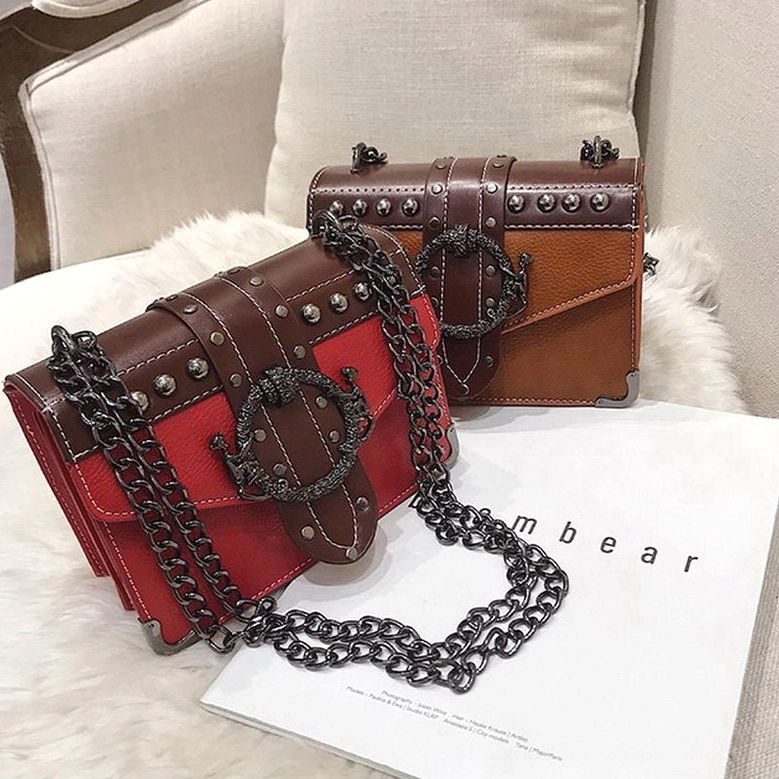 Red and brown gothic leather shoulder bags with vintage buckle locks and chain straps - lifestyle display
