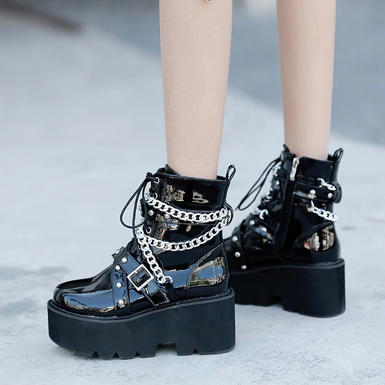 Black gothic boots with silver chain details displayed on white background showcasing metal hardware craftsmanship