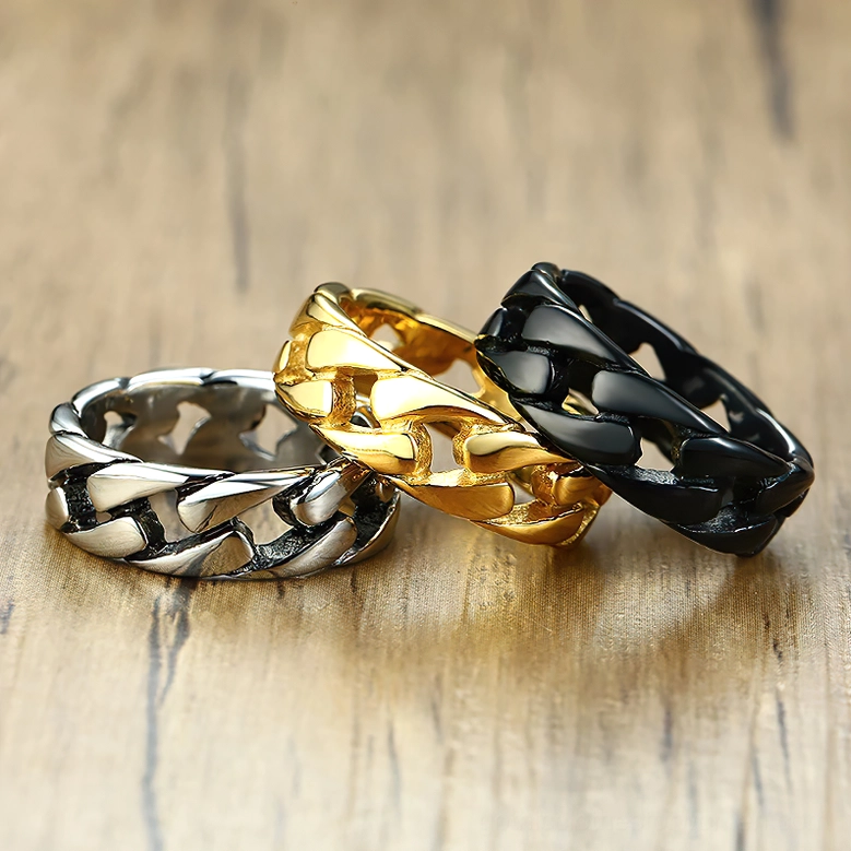Three-piece gothic chain link ring collection in black, gold, and silver stainless steel, flat lay composition