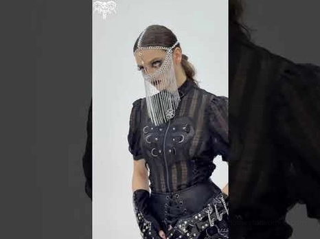 Gothic chain face veil headpiece styled with dark gothic leather outfit on model, dramatic studio lighting