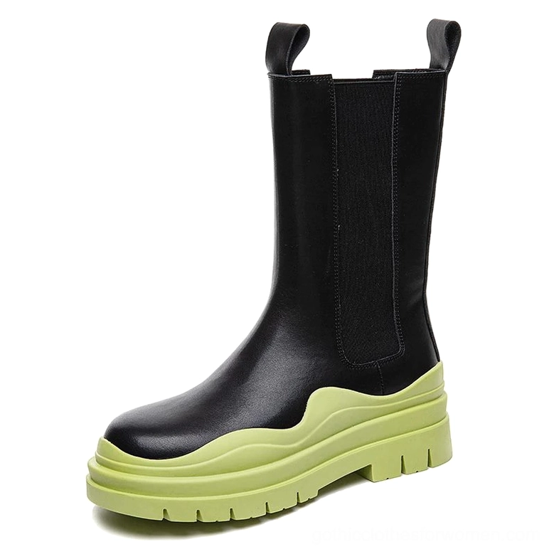 Black genuine leather mid-calf platform boots with lime green wavy thick sole, alternative fashion styling, front three-quarter angle