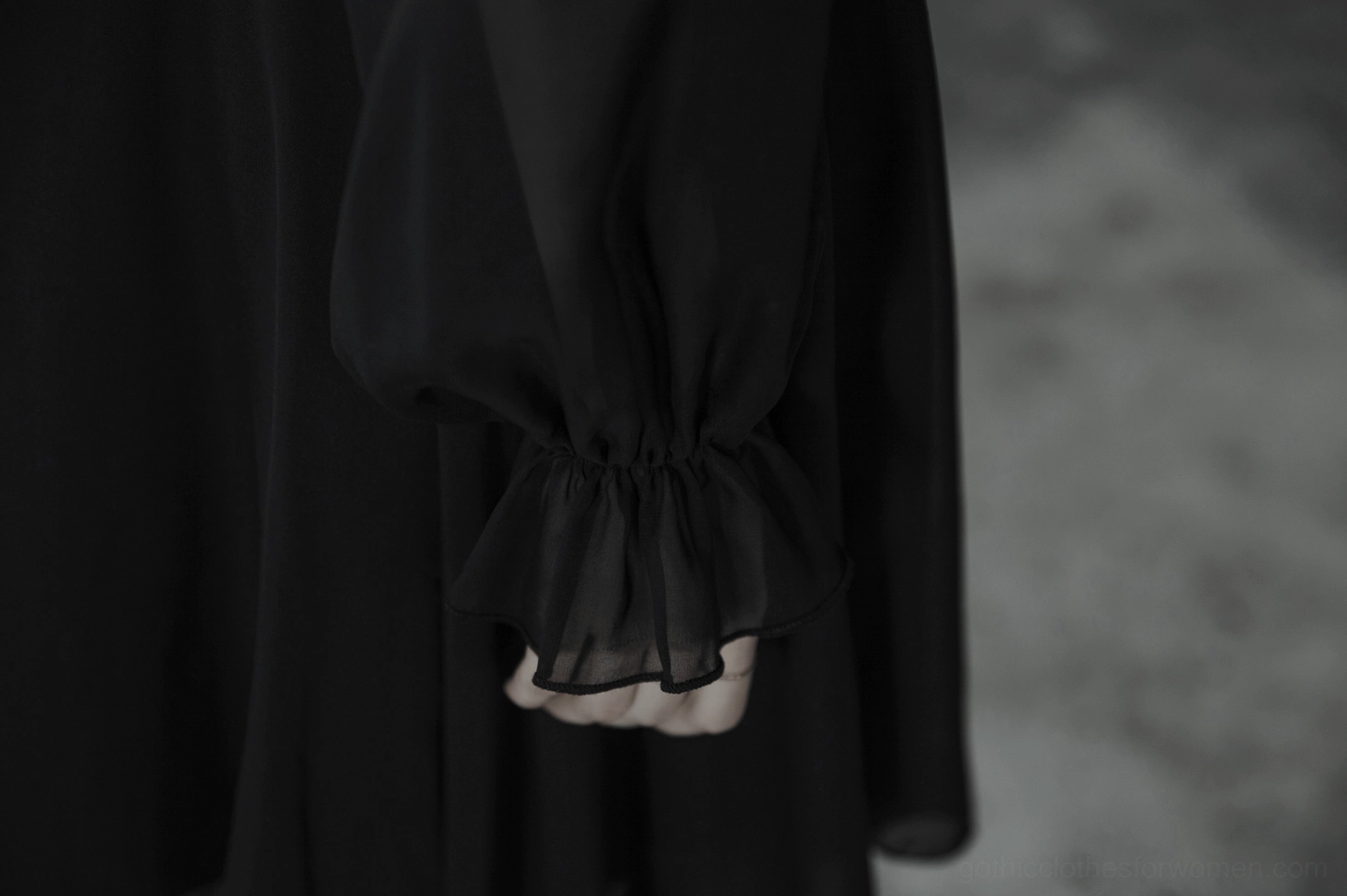 Black asymmetrical chiffon gothic dress mannequin display showing V-neck ruffled placket and voluminous sleeve details