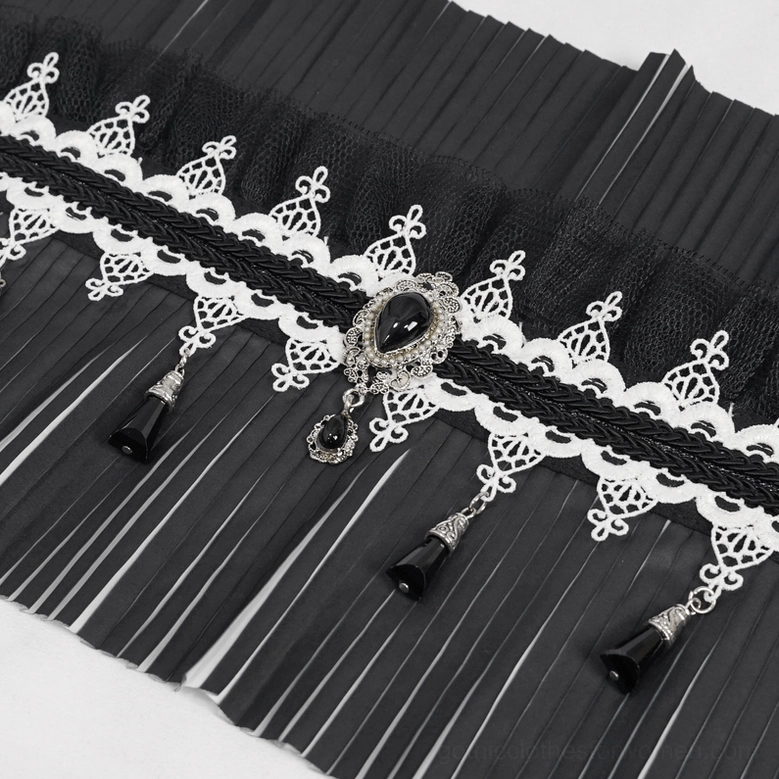 Macro detail of gothic collar embellishments featuring vintage lace, black gem pendant and metal tassel charms
