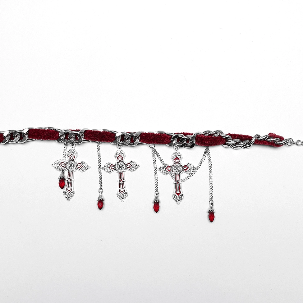 Flat lay side view of gothic cross choker necklace showing ornate cross pendants with red teardrop crystal dangles and silver-toned metal details