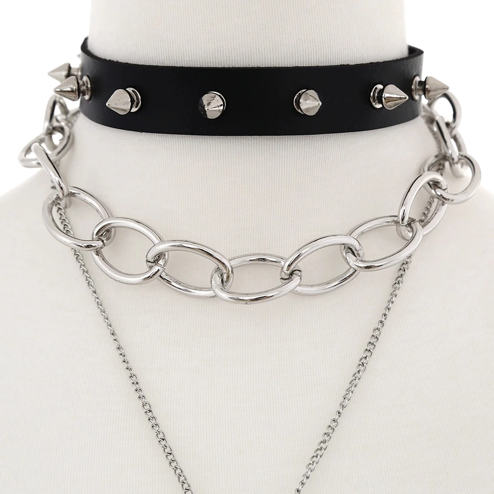 Close-up detail of black leather choker with silver cone studs and thick metal curb chain