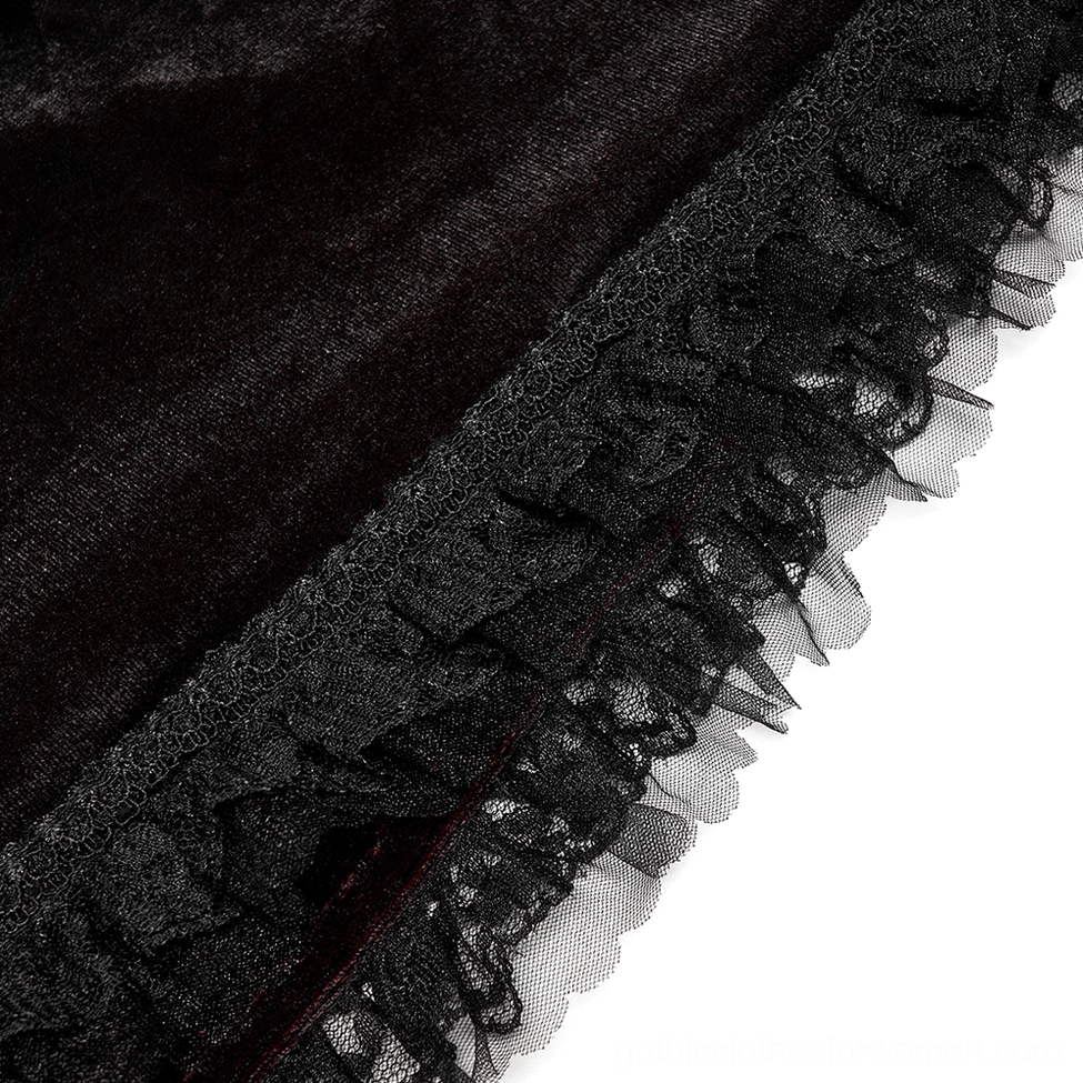 Close-up detail of gothic cloak ornate black clasp, carved embellishment, and crimson red inner fabric texture