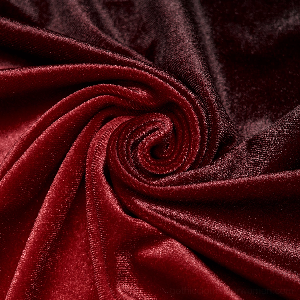 Detailed close-up view of ornate black metal clasp and carved embellishments on gothic velvet cloak