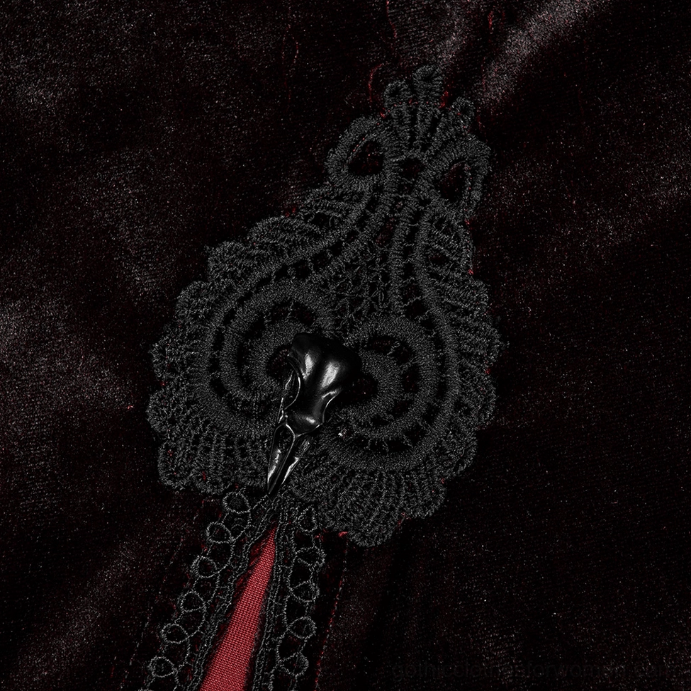 Close-up detail of gothic cloak ornate skull-inspired clasp with intricate lace trim and vibrant red inner lining