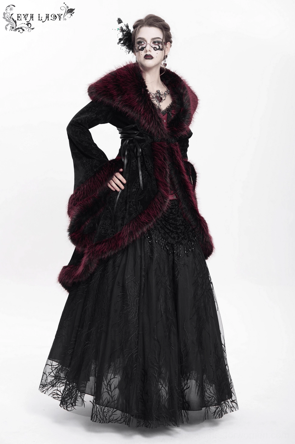 Three-quarter back view of gothic coat worn by model highlighting rear silhouette, high-low hem, and burgundy fur-trimmed details