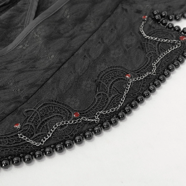 Close-up detail of beaded chain and red gem accents on gothic coat decorative trim