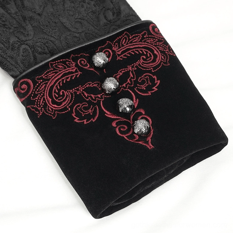 Close-up of black gothic coat cuff embroidery, featuring red paisley design and ornamental skull buttons