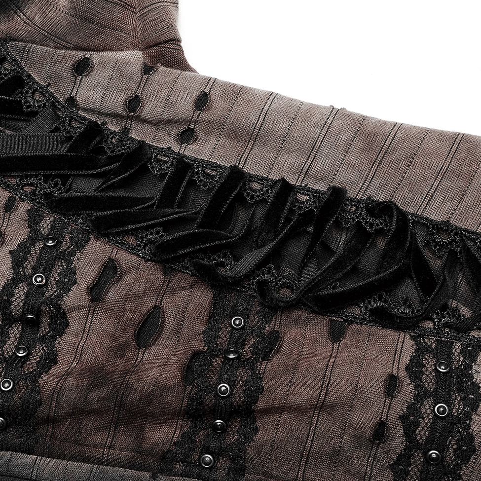 Close-up detail of gothic coat front trim showing ribbon lace, metal studs, and perforated distressed fabric texture
