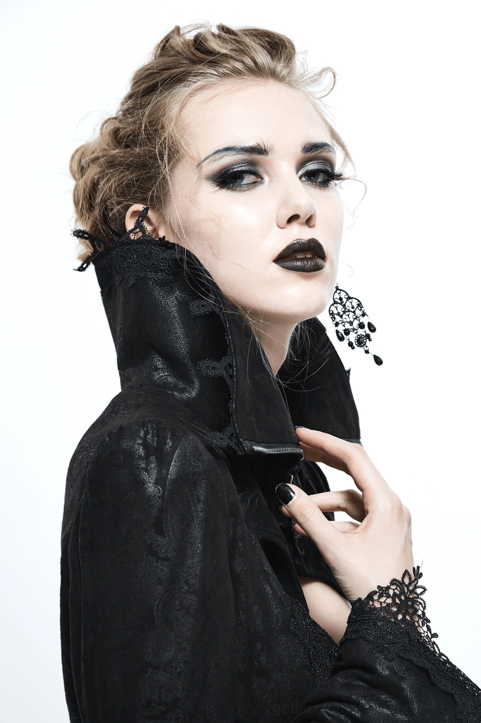 Gothic coat model shot showing lace-trimmed cuffs, embossed fabric details, metal hardware, and full-length flowing silhouette