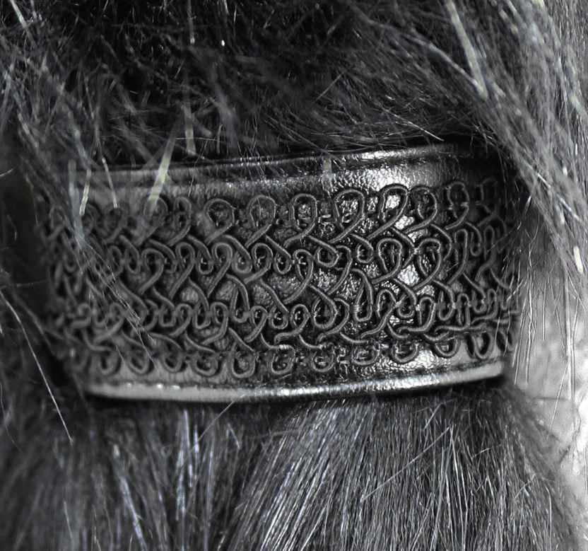 Detailed close-up of Celtic knot metal trim and black faux fur cuff decoration on gothic coat