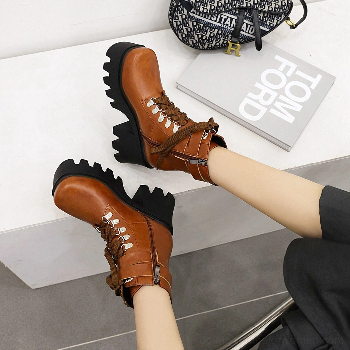 Gothic platform combat boots featuring buckle and stitching decorations, architectural silhouette emphasizing alternative aesthetic appeal