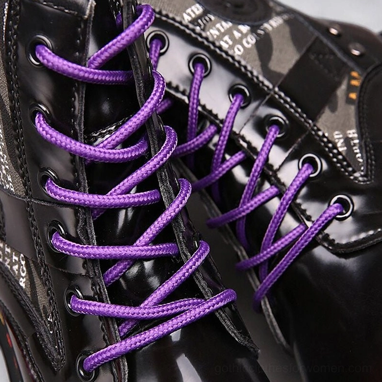 Close-up detail of purple round laces and branded canvas panels on glossy black gothic combat boot