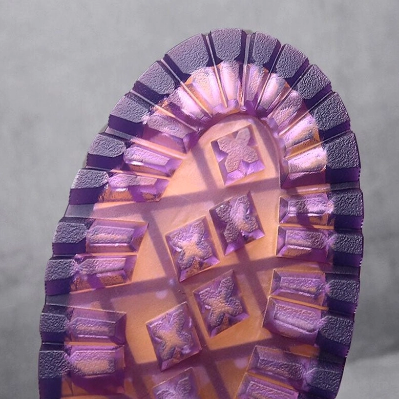 Translucent purple rubber lug tread outsole of gothic combat boots, bottom view