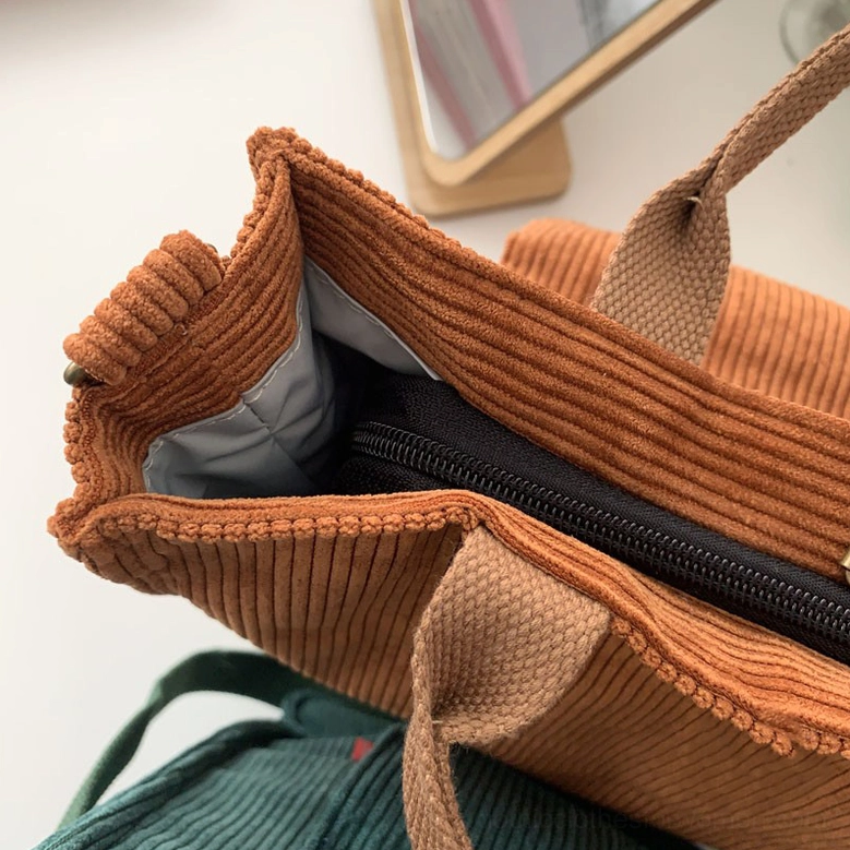 Adjustable shoulder strap detail on gothic corduroy tote bag showing crossbody convertibility and premium hardware