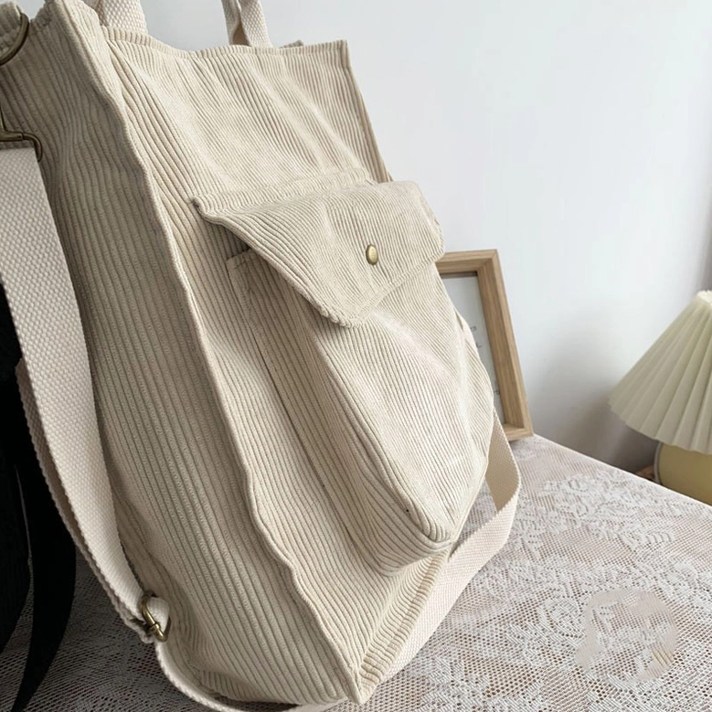 Women's gothic corduroy tote bag back view showing criss-cross detailing and structured silhouette for minimalist dark fashion