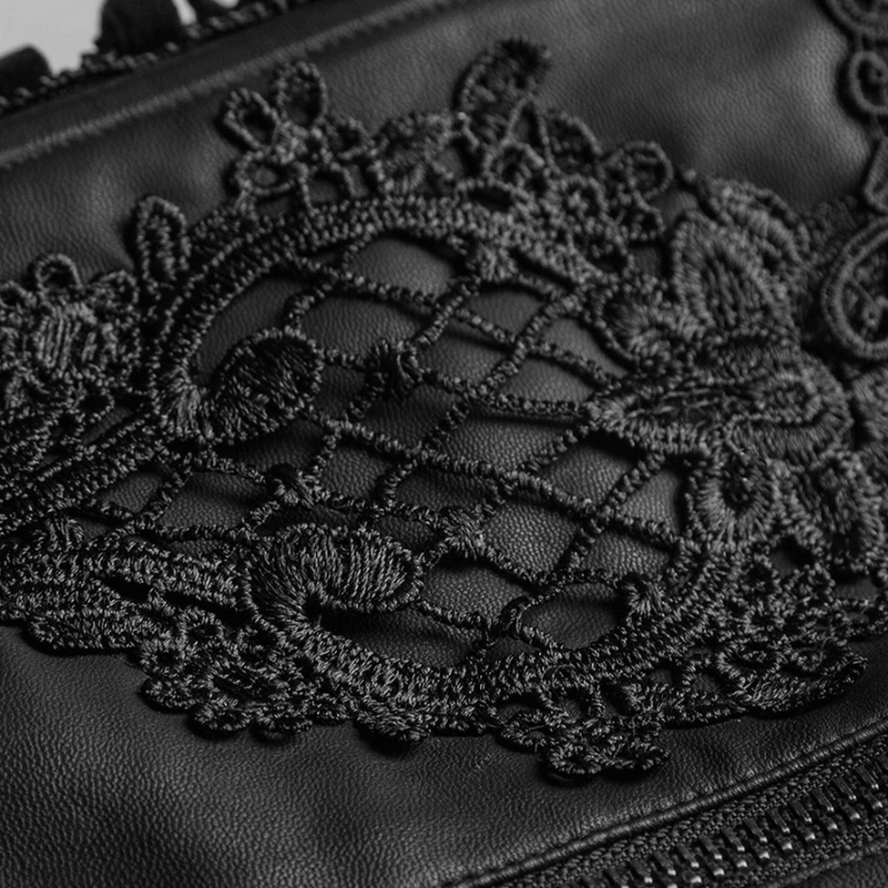 Macro close-up detail of black floral embroidery on gothic corset belt showcasing intricate crochet lace pattern on matte leather surface