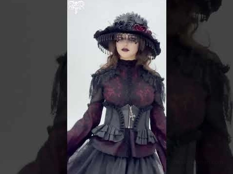 Black gothic corset waist belt with cross zipper worn with vintage gothic outfit and wide-brim hat, full body styling
