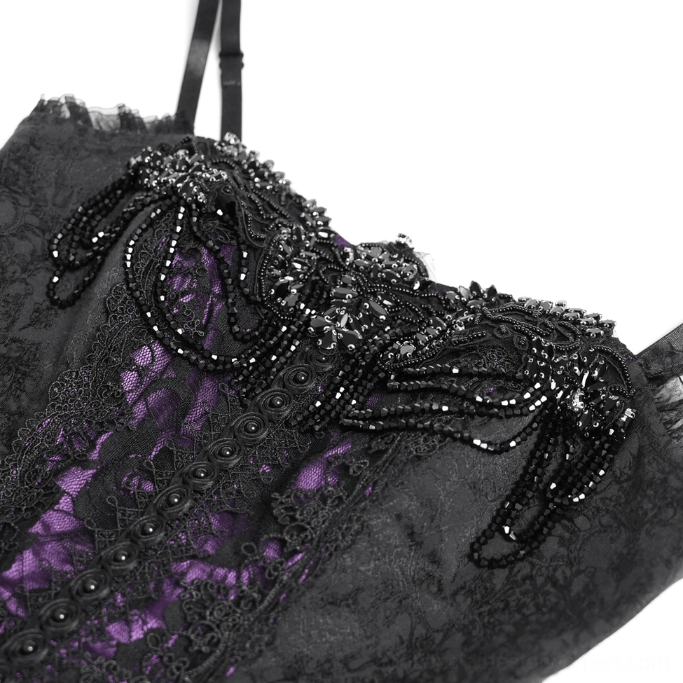 Close-up detail of gothic corset dress showing beaded floral decoration and black lace overlay fabric