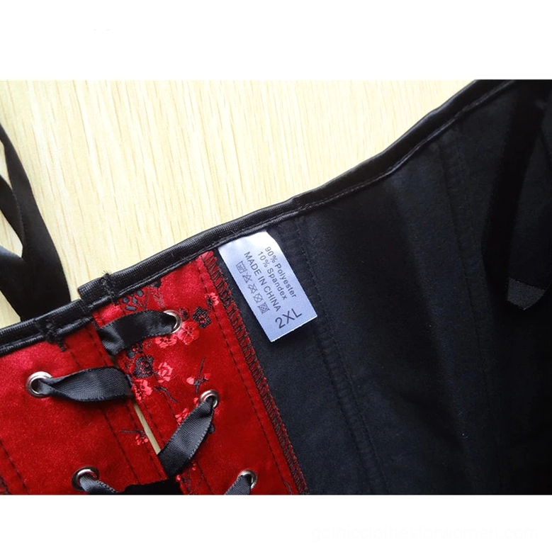 Close-up detail of red gothic corset interior black satin lining with size tag and metal lace eyelets, side view on wooden surface
