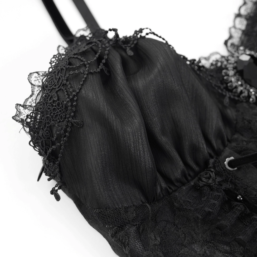 Detailed view of sheer cup fabric with black lace edging and decorative gem pendant accent
