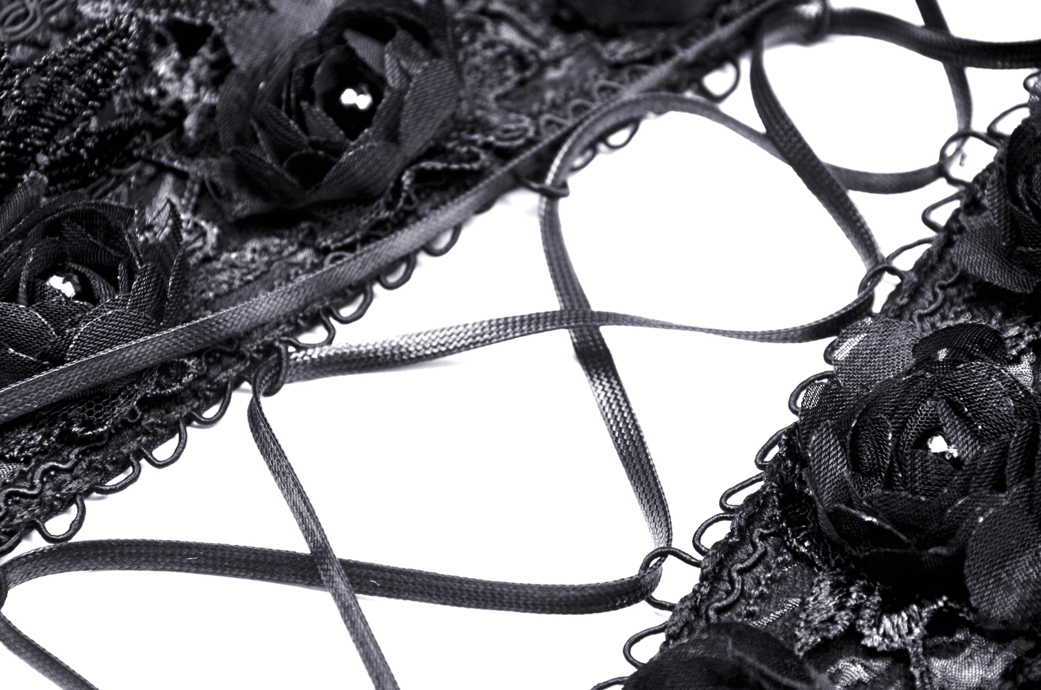 Close-up of gothic corset lace-up closure showing satin ribbon and 3D rose decorations on embossed lace