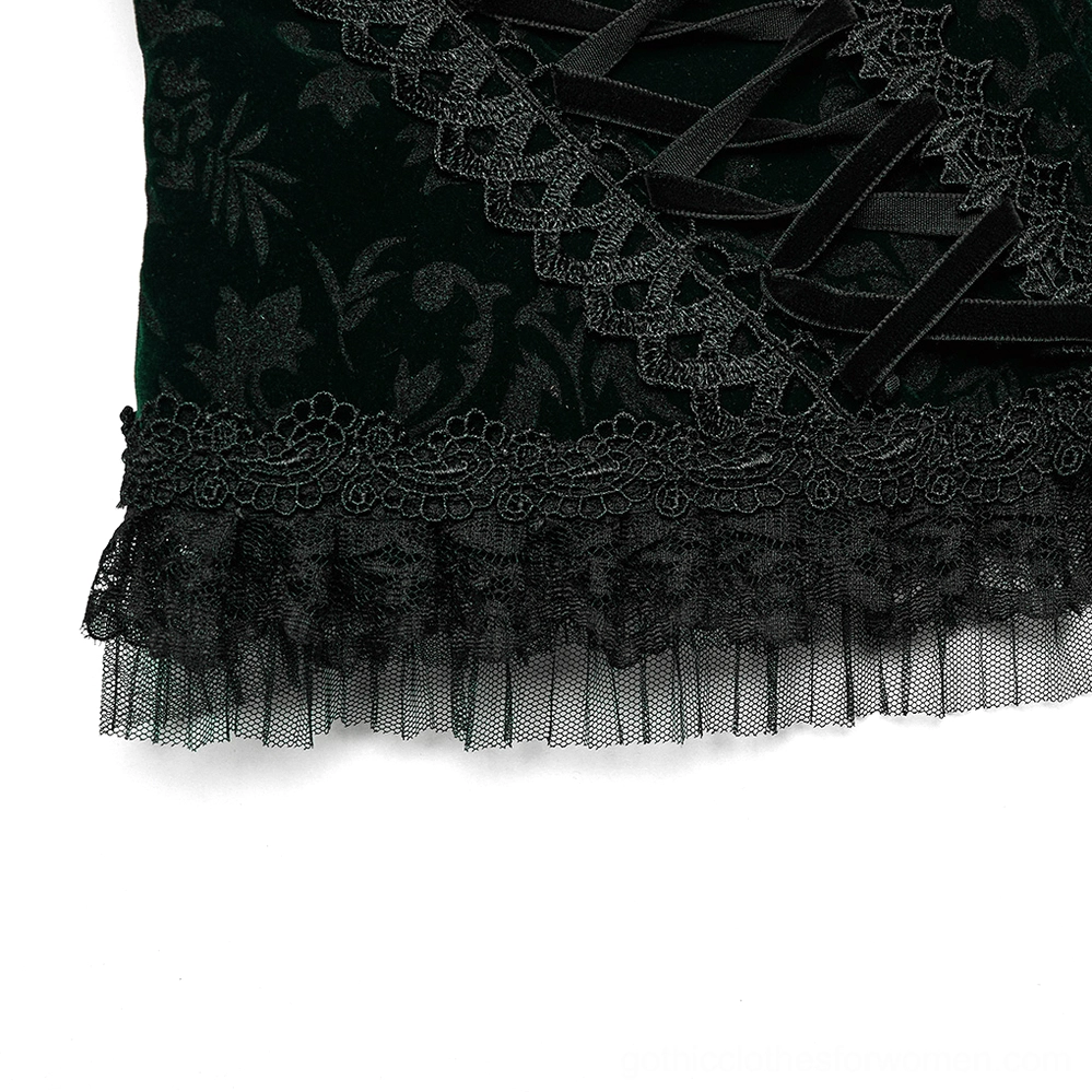 Low side close-up of corset hem showing sheer mesh ruffle, embroidered lace trim detail, floral velveteen base fabric, and refined hem construction