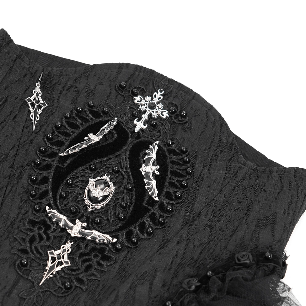 Detailed shot of gothic corset construction showing textured black fabric with intricate metal gothic accents and beadwork