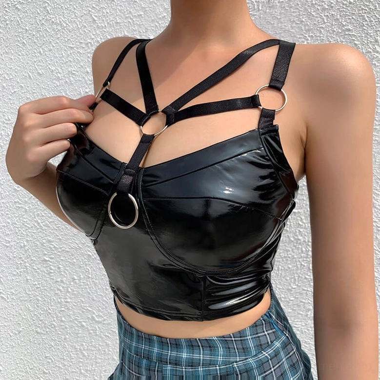 Frontal styling of black gothic crop cami featuring metal O-ring harness and patent leather construction